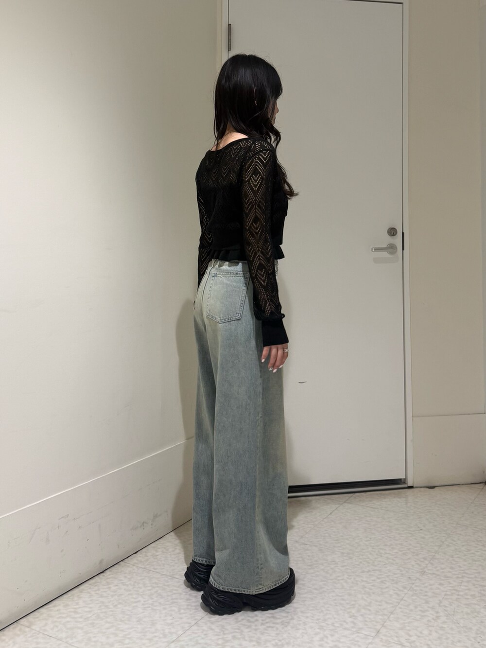 ブラック系のカーディガン/ボレロ、ブルー系のデニムパンツ、ブラック系のサンダルを着用したレディースの春コーディネートの2枚目の写真