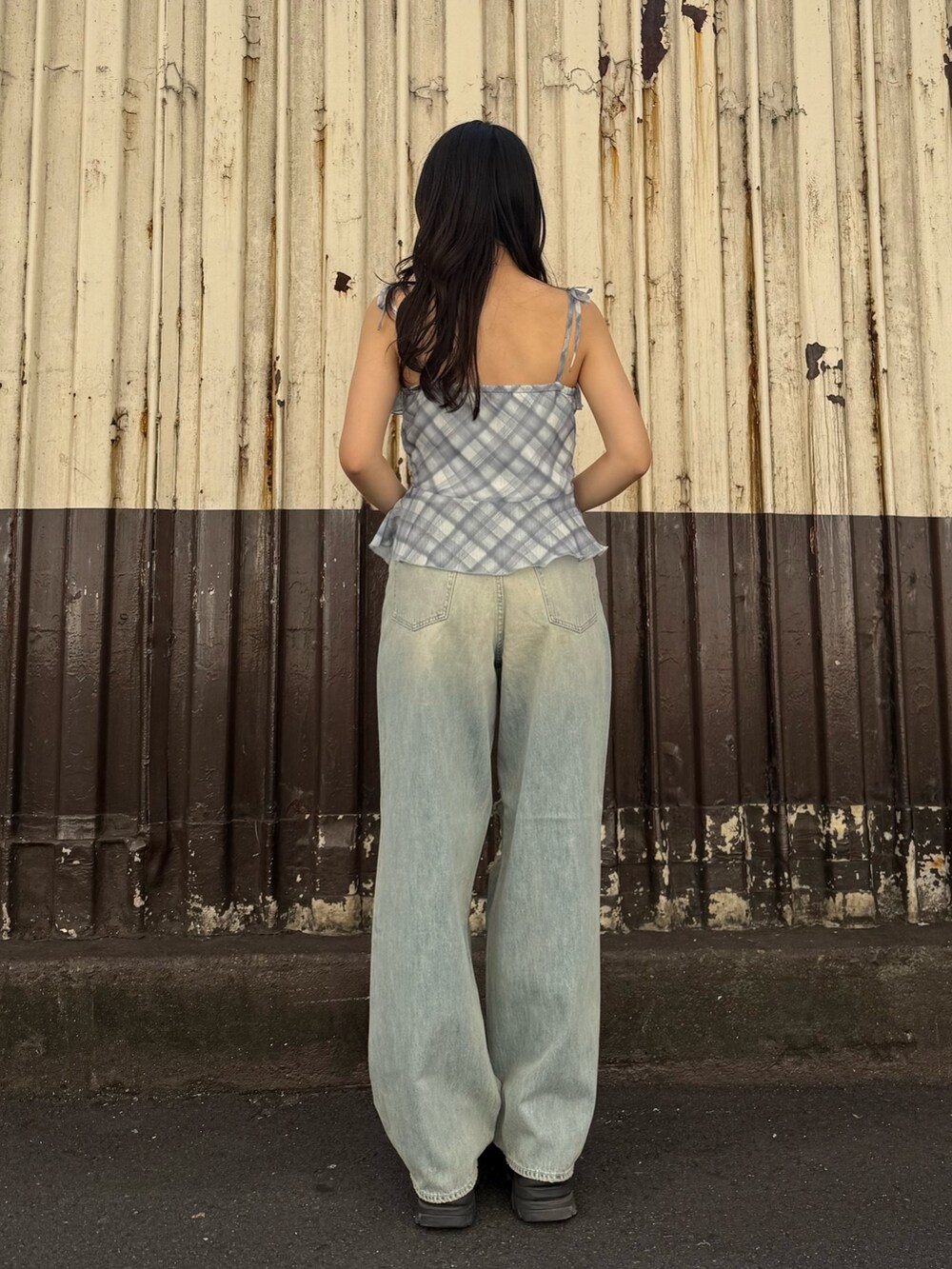 ブラウン系のサンダル、ブルー系のデニムパンツ、ブルー系のキャミソールを着用したレディースの夏コーディネートの3枚目の写真