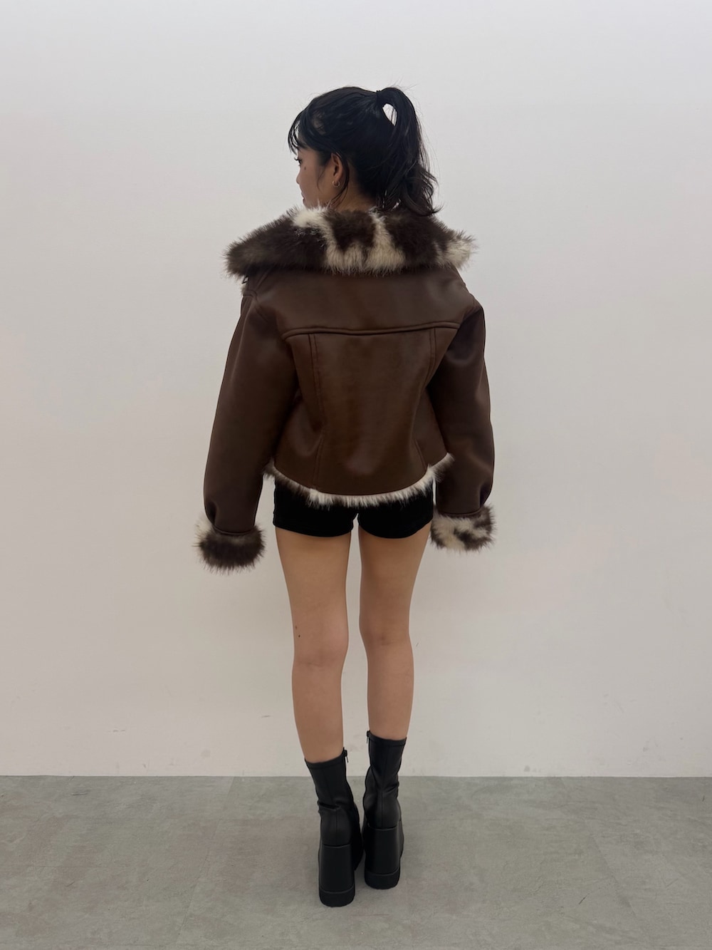 ピンク系のボストンバッグ、ピンク系のニット/セーター、ブルー系のデニムパンツを着用したレディースの秋コーディネートの5枚目の写真