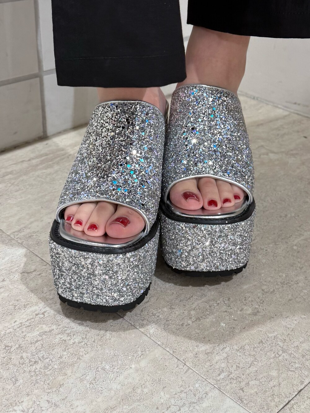 ブルー系のニット/セーター、シルバー系のサンダル、ブラック系のデニムパンツを着用したレディースの夏コーディネートの5枚目の写真
