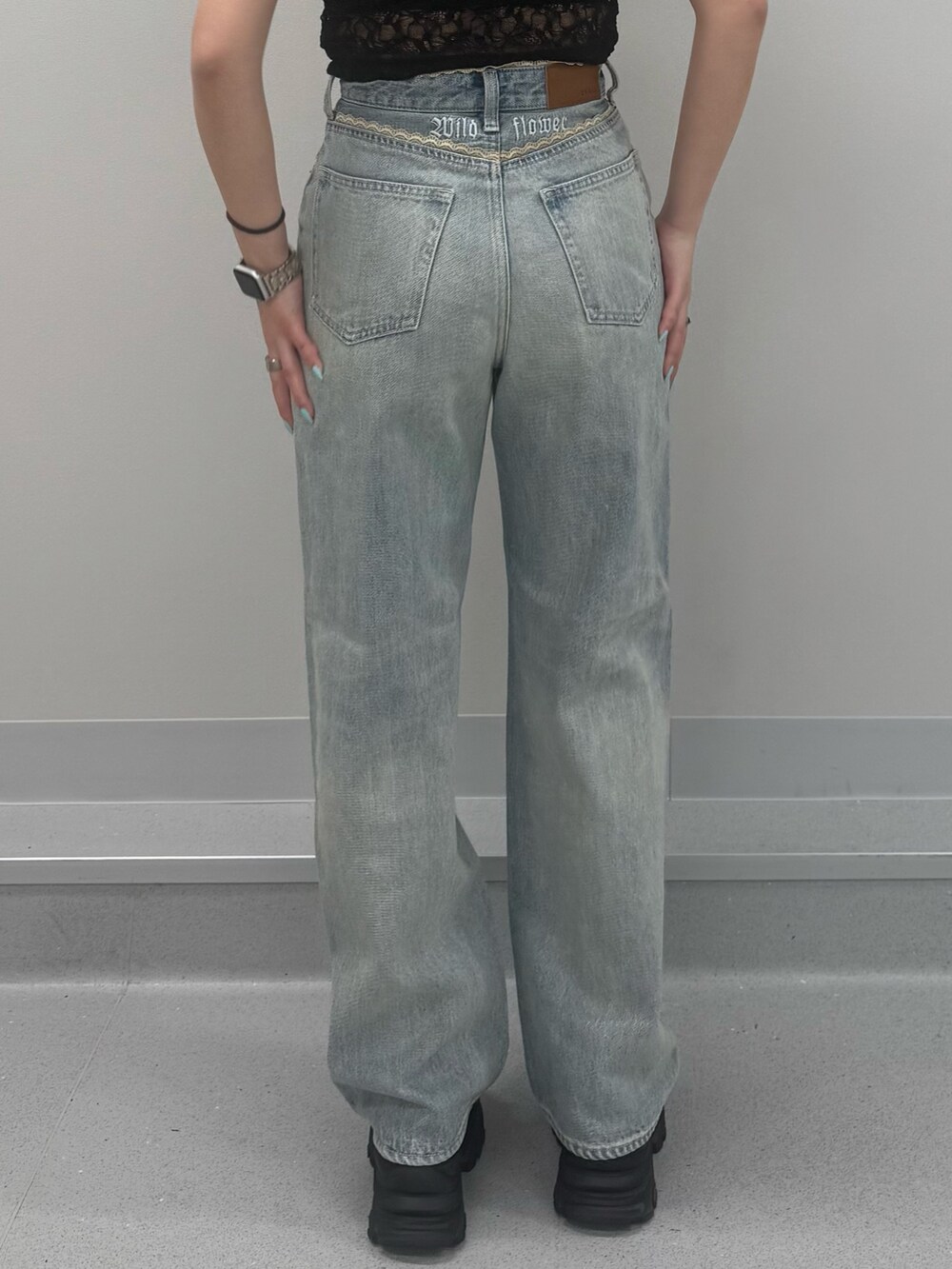 ブルー系のデニムパンツ、ブラウン系のサンダル、ブラック系のTシャツ/カットソーを着用したレディースの春コーディネートの5枚目の写真