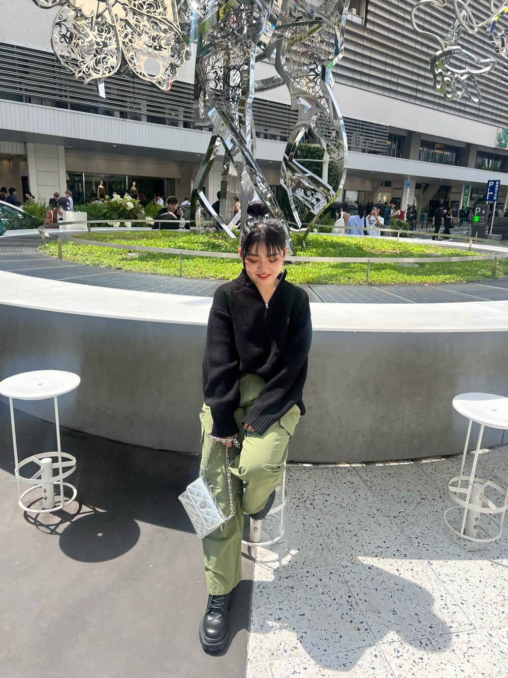 グリーン系のカーゴパンツ、ブラック系のショルダーバッグ、ブラック系のブーツを着用したレディースの夏コーディネートの6枚目の写真