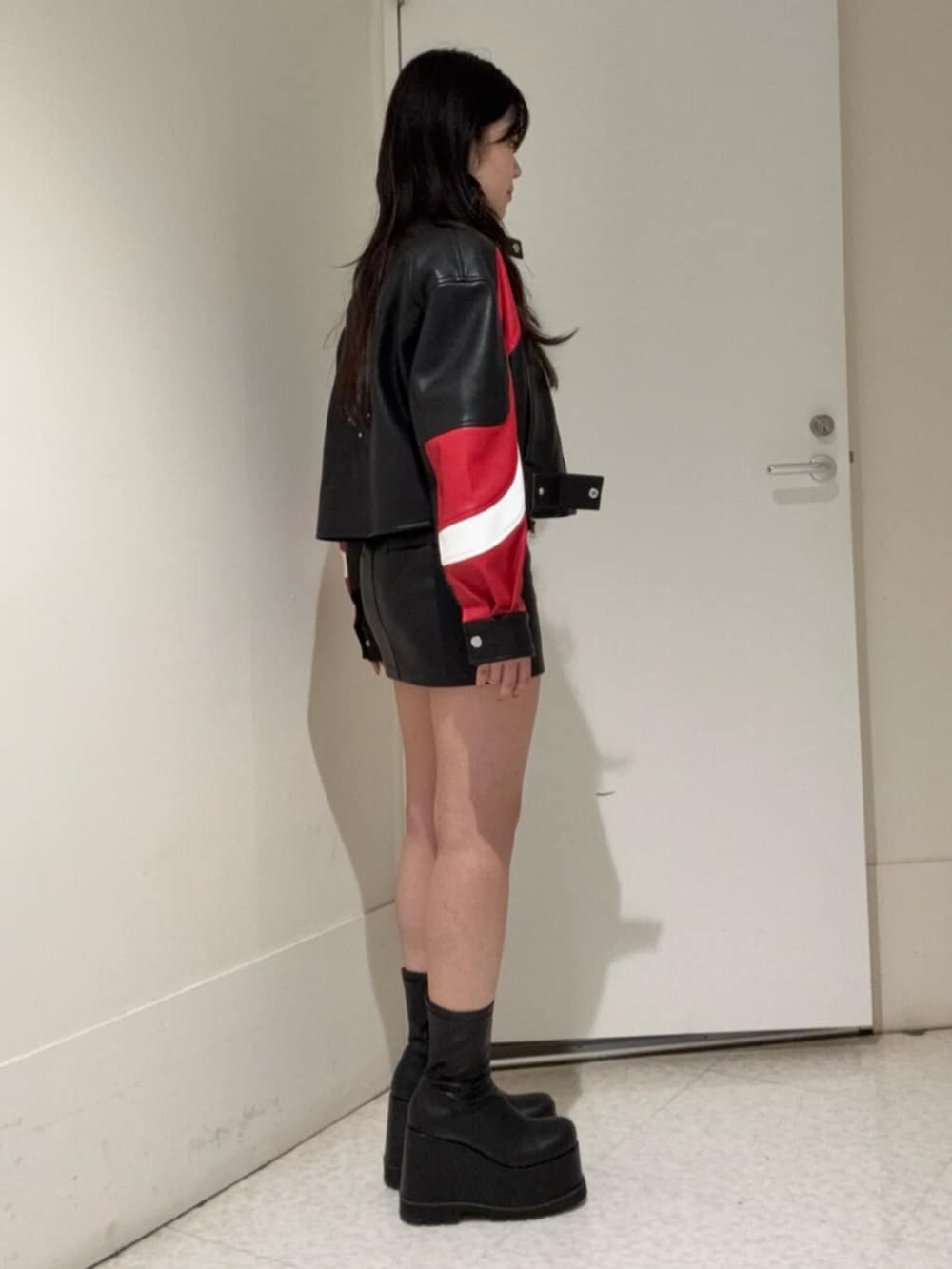 ブラック系のブーツ、ブラック系のスカート、その他のブルゾンを着用したレディースの冬コーディネートの2枚目の写真