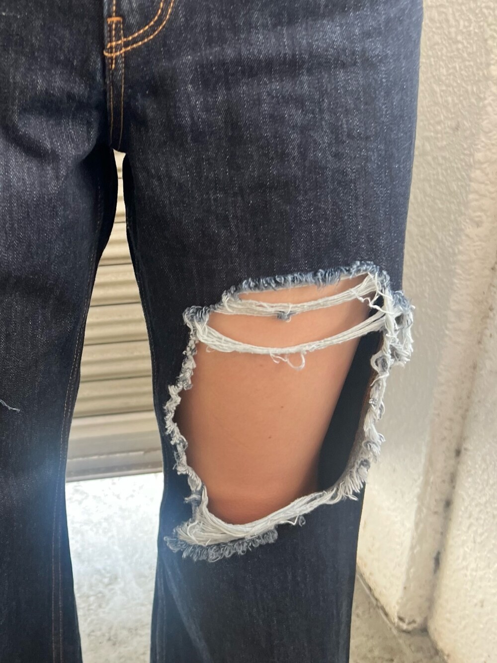 ブルー系のデニムパンツ、ホワイト系のTシャツ/カットソー、ブラック系のハンドバッグを着用したレディースの夏コーディネートの4枚目の写真