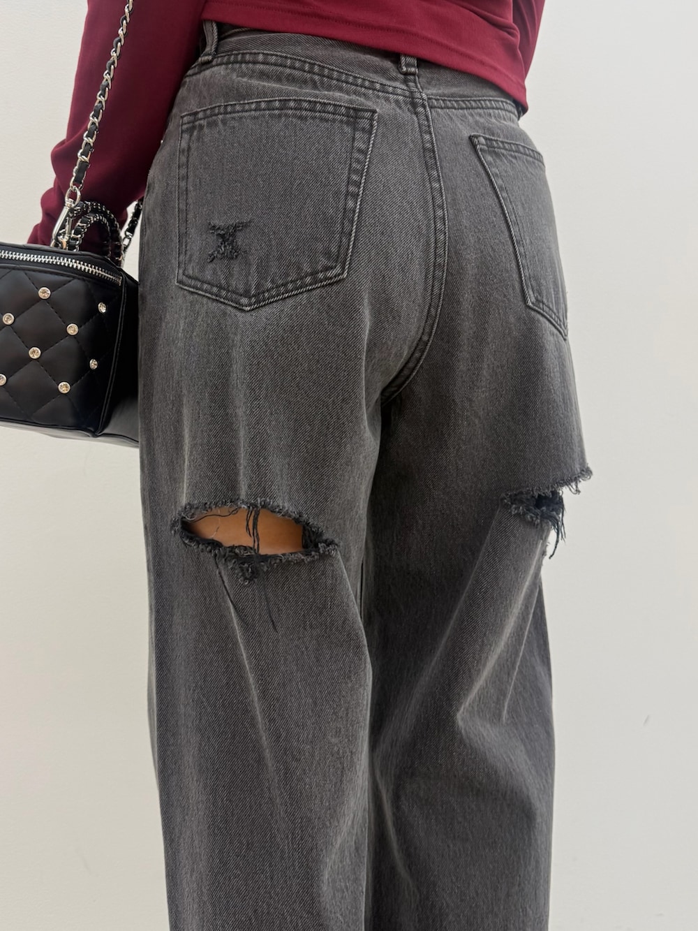 レッド系のニット/セーター、ブラック系のデニムパンツ、レッド系のスニーカーを着用したレディースの秋コーディネートの5枚目の写真