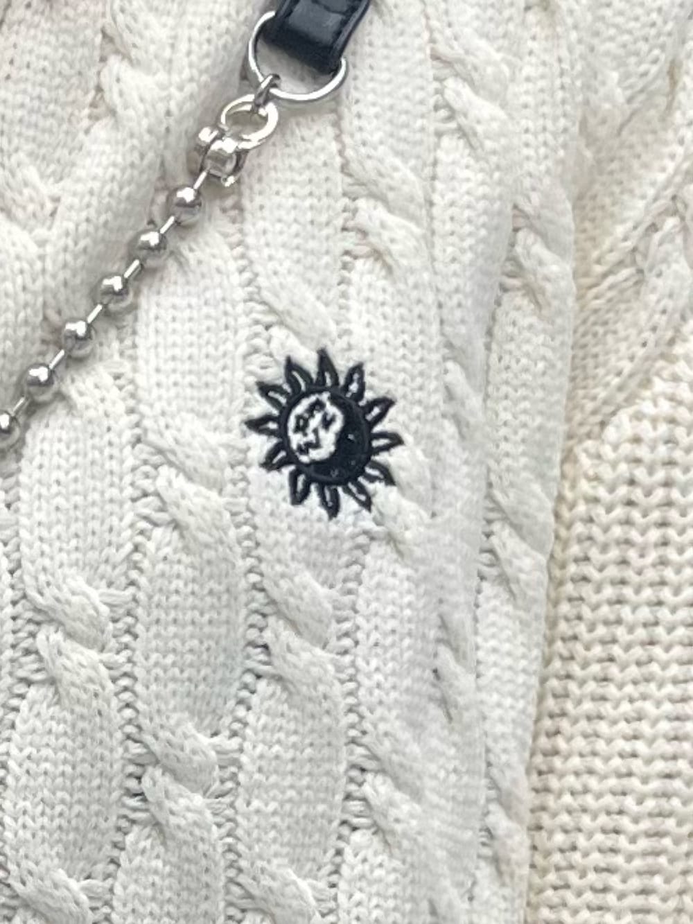 ホワイト系のニット/セーター、ブラック系のブーツ、ブラック系のショルダーバッグを着用したレディースの夏コーディネートの5枚目の写真