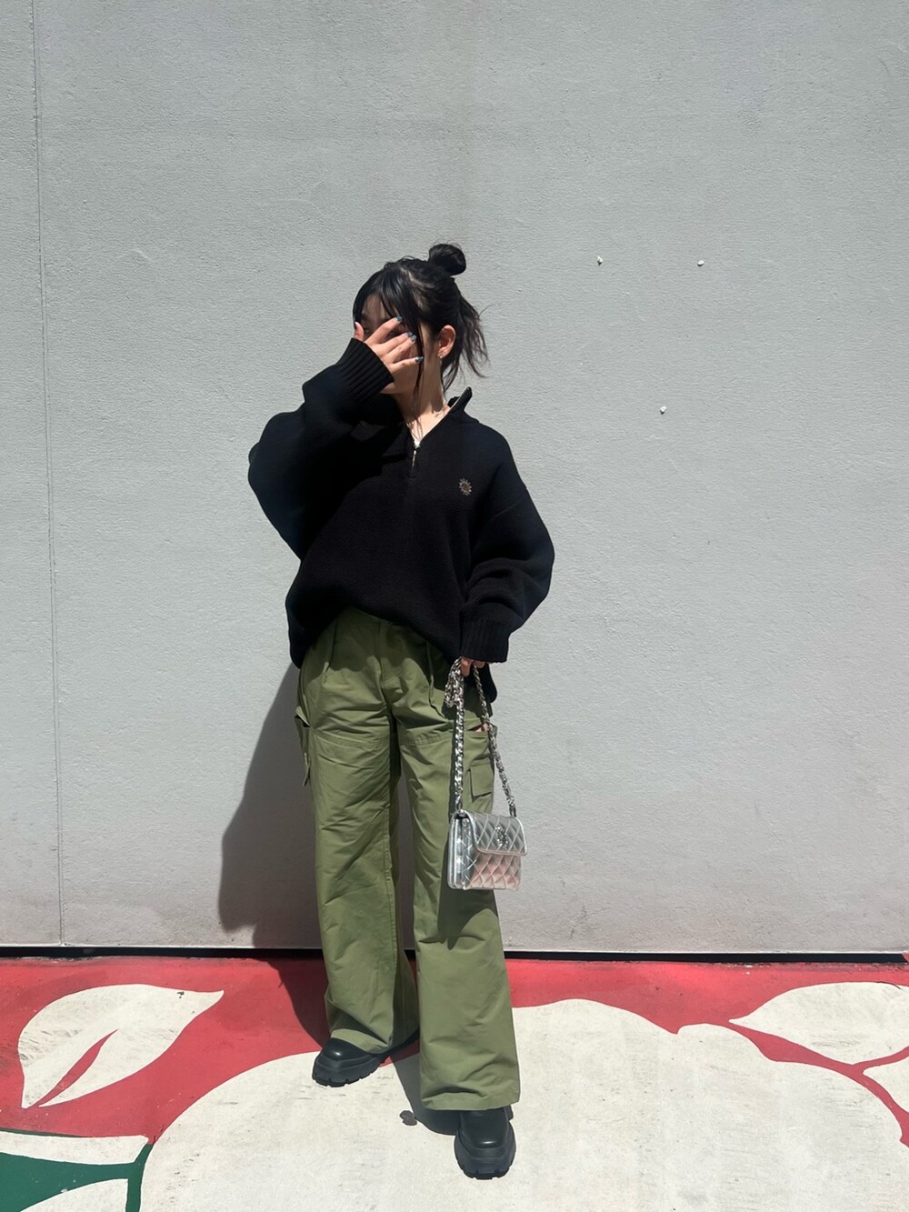 グリーン系のカーゴパンツ、ブラック系のショルダーバッグ、ブラック系のブーツを着用したレディースの夏コーディネートの3枚目の写真