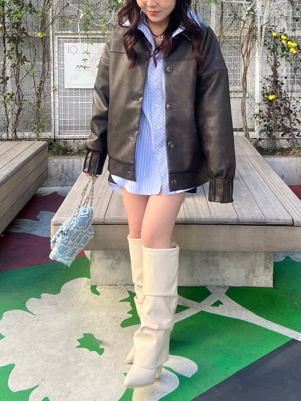 ホワイト系のブーツ、ブラウン系のブルゾン、ブルー系のシャツ/ブラウスを着用したレディースの春コーディネートの2枚目の写真