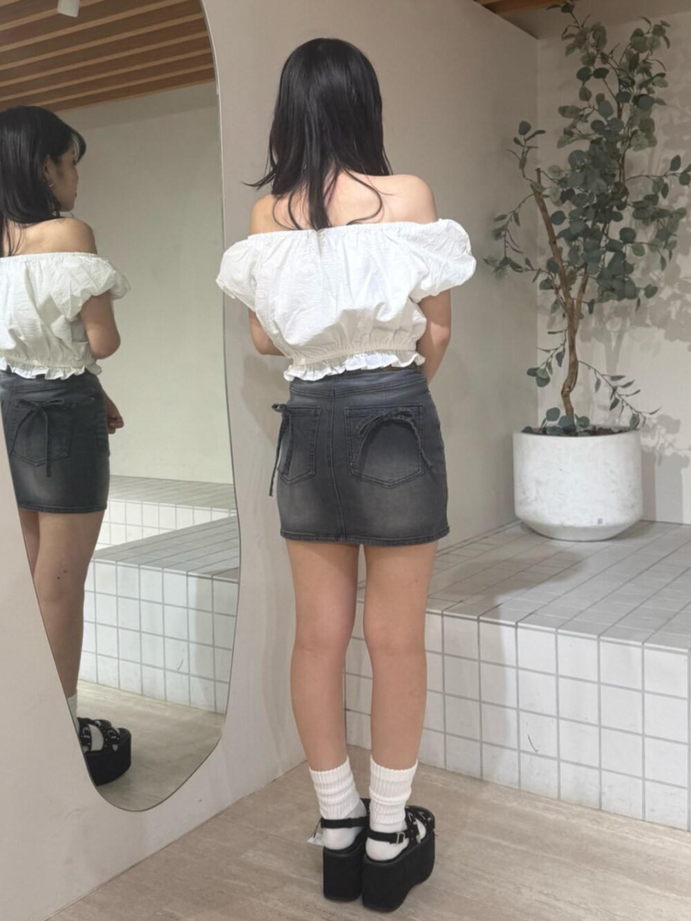 ホワイト系のシャツ/ブラウス、ブラック系のデニムスカート、ブラック系のサンダルを着用したレディースの夏コーディネートの3枚目の写真