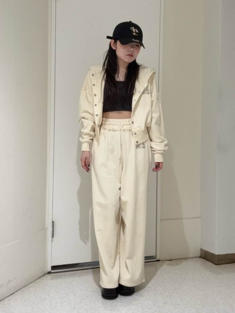 ブラック系のブーツ、ホワイト系のパーカー、ホワイト系のスウェットパンツを着用したレディースの春コーディネートの4枚目の写真