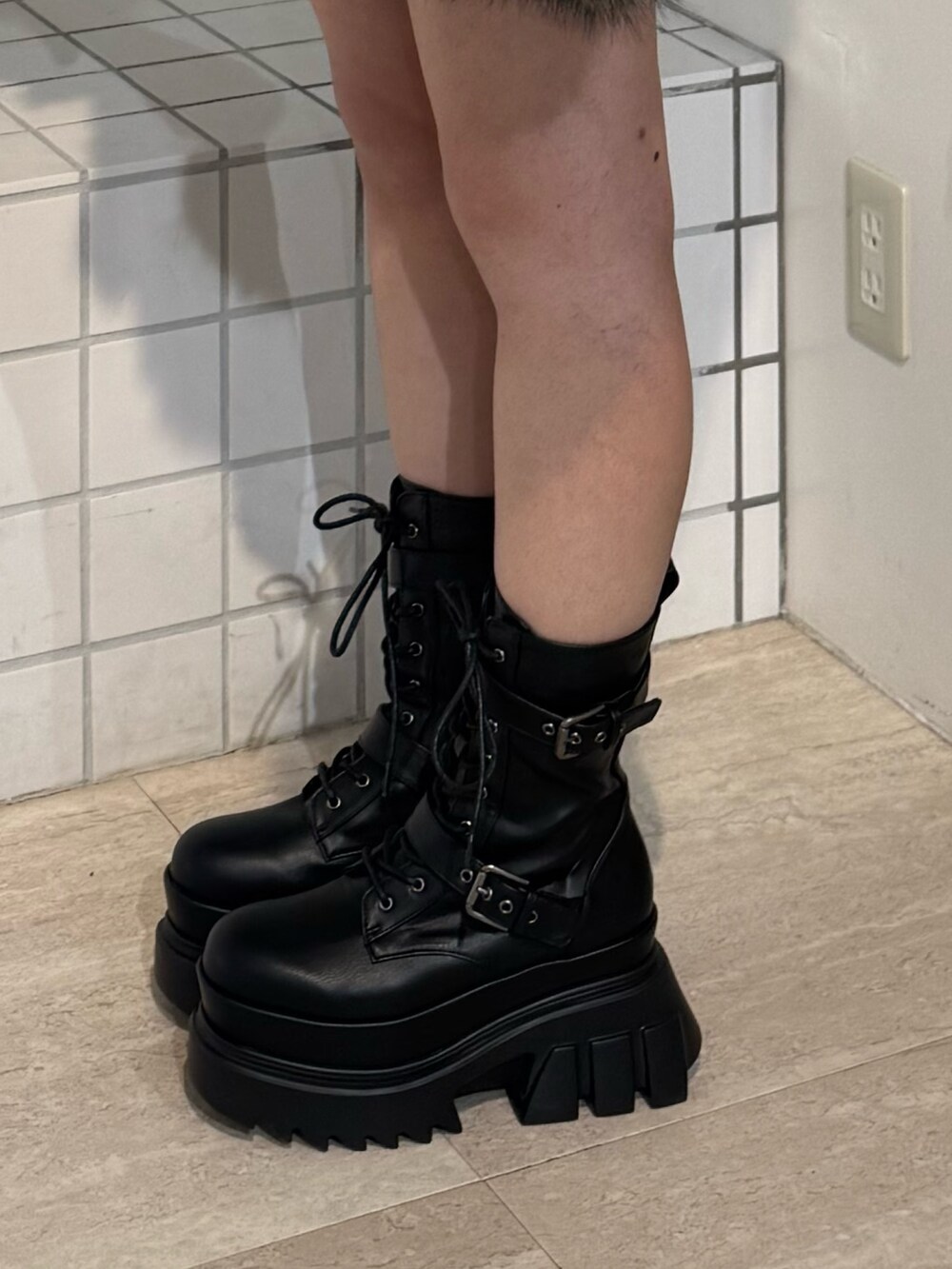 ブラウン系のブルゾン、ブルー系のデニムスカート、ブラック系のブーツを着用したレディースの秋コーディネートの5枚目の写真