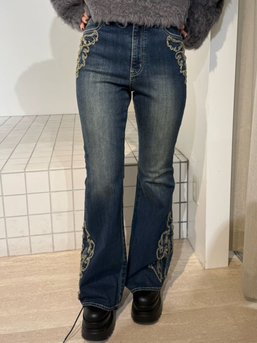 ブルー系のデニムパンツ、ブラック系のブーツ、ブラウン系のブルゾンを着用したレディースの秋コーディネートの4枚目の写真