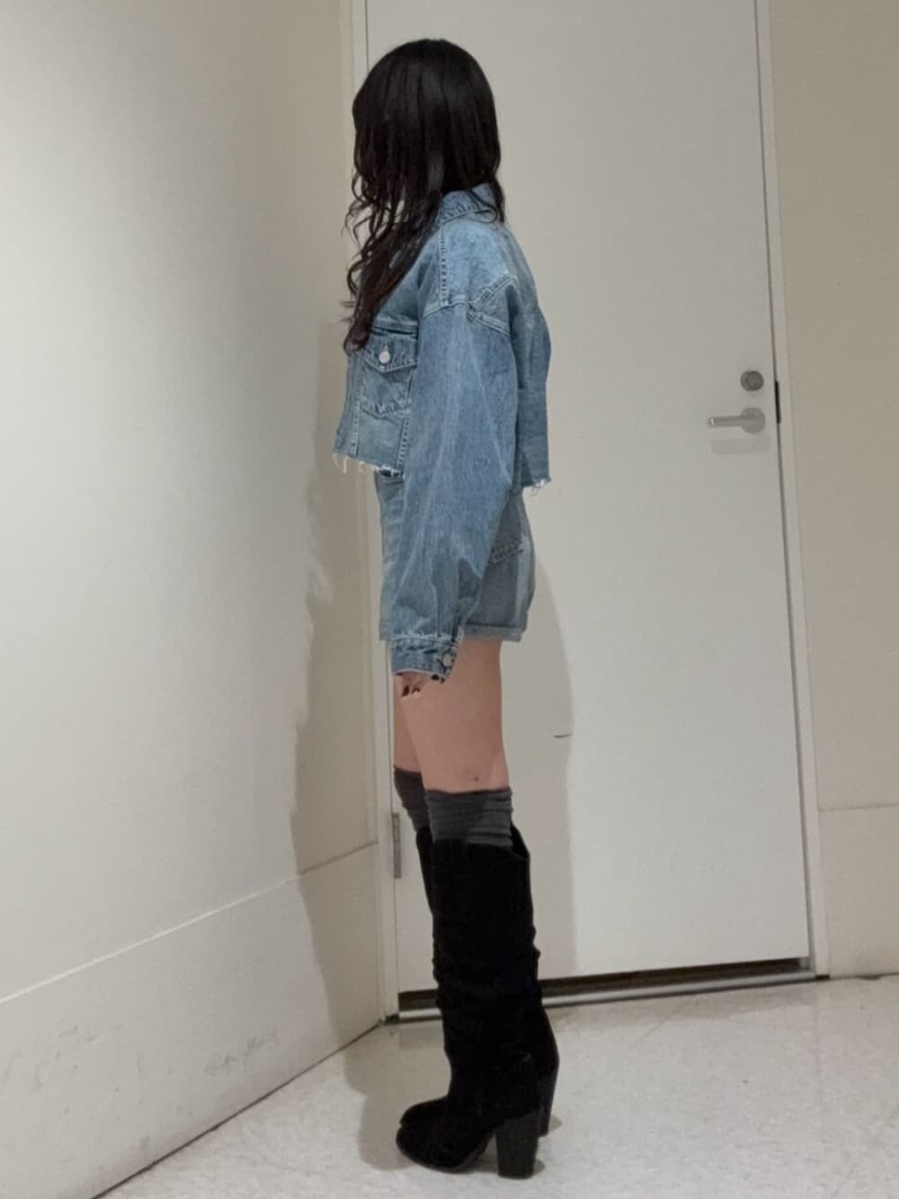 ブルー系のデニムパンツ、ブルー系のデニムジャケット、ブラック系のブーツを着用したレディースの冬コーディネートの2枚目の写真