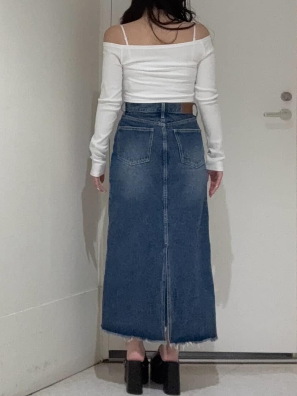 ホワイト系のTシャツ/カットソー、ブラック系のサンダル、ブルー系のデニムスカートを着用したレディースの春コーディネートの3枚目の写真