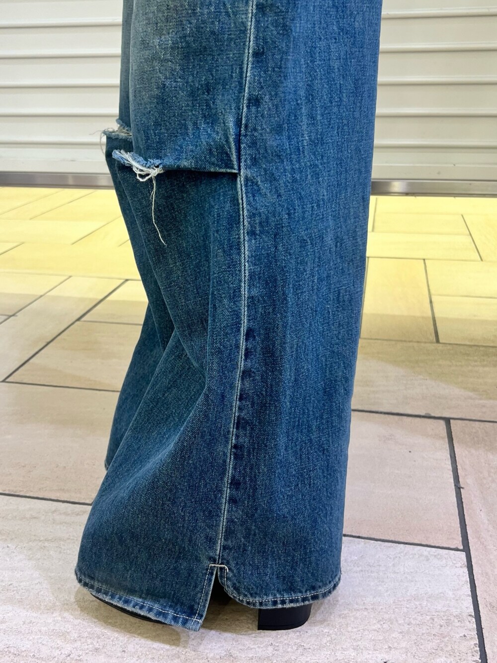 ブルー系のデニムパンツ、ブラック系のカーディガン/ボレロ、ブラック系のブーツを着用したレディースの冬コーディネートの8枚目の写真