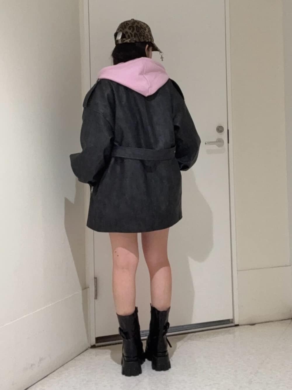 ピンク系のパーカー、ブラック系のライダースジャケット、ブラック系のブーツを着用したレディースの春コーディネートの3枚目の写真