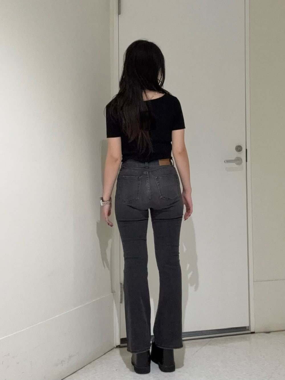 ブラック系のデニムパンツ、ブラック系のブーツ、ブラック系のニット/セーターを着用したレディースの春コーディネートの3枚目の写真