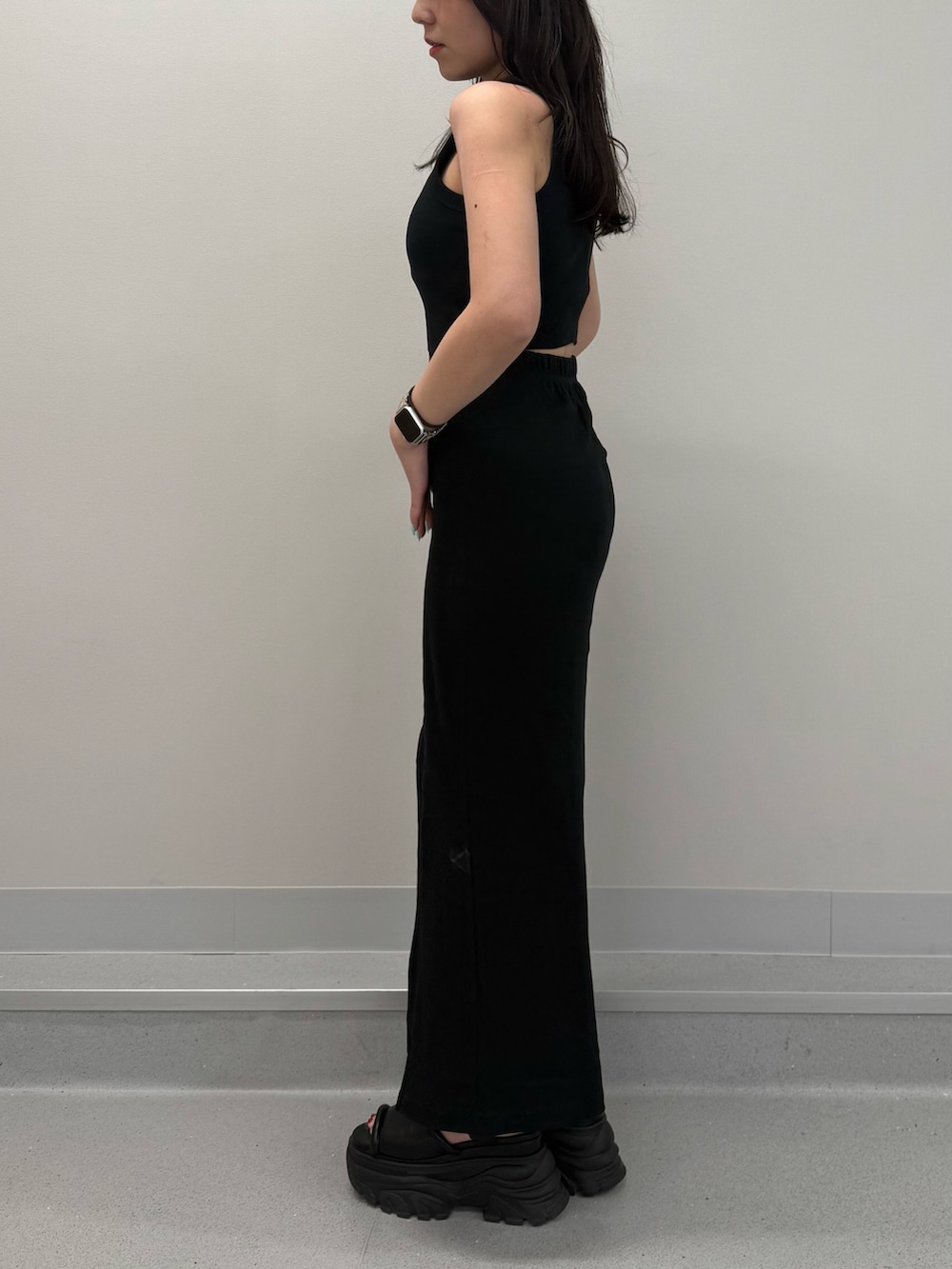 ブラック系のワンピース、ブラウン系のサンダルを着用したレディースの春コーディネートの2枚目の写真