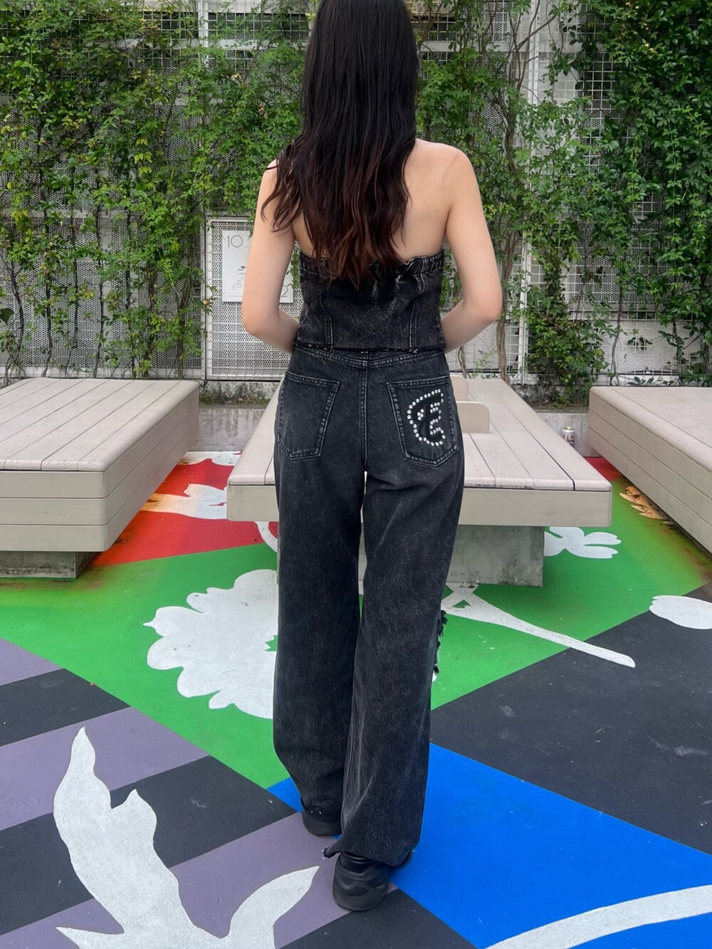 ブラック系のデニムパンツ、ブラック系のサンダル、ブラック系のキャミソールを着用したレディースの夏コーディネートの4枚目の写真