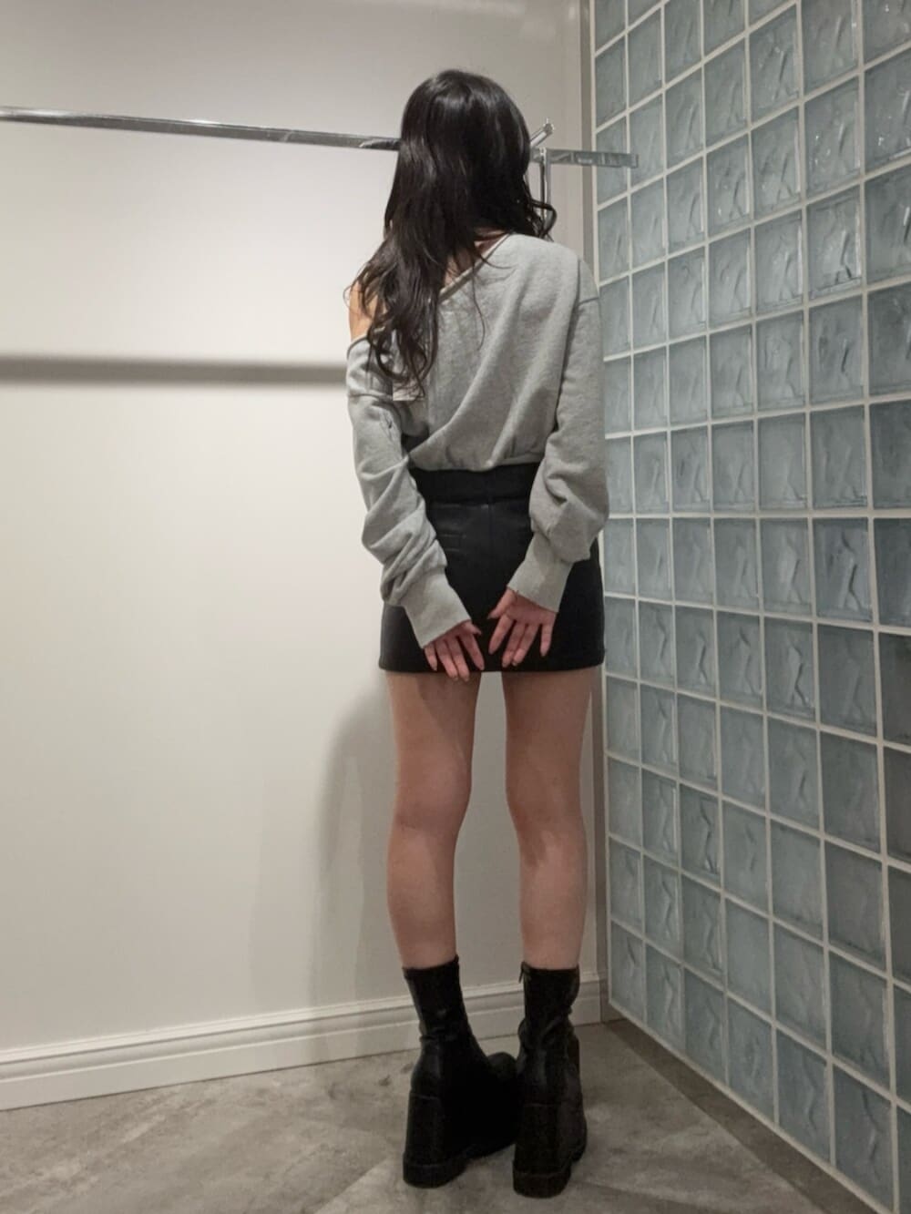 ブラック系のブーツ、ブラック系のスカート、グレー系のスウェットを着用したレディースの冬コーディネートの3枚目の写真