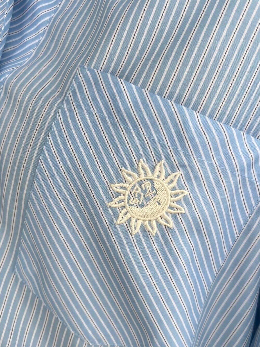 ブルー系のデニムスカート、ブルー系のシャツ/ブラウス、ホワイト系のショルダーバッグを着用したレディースの春コーディネートの6枚目の写真