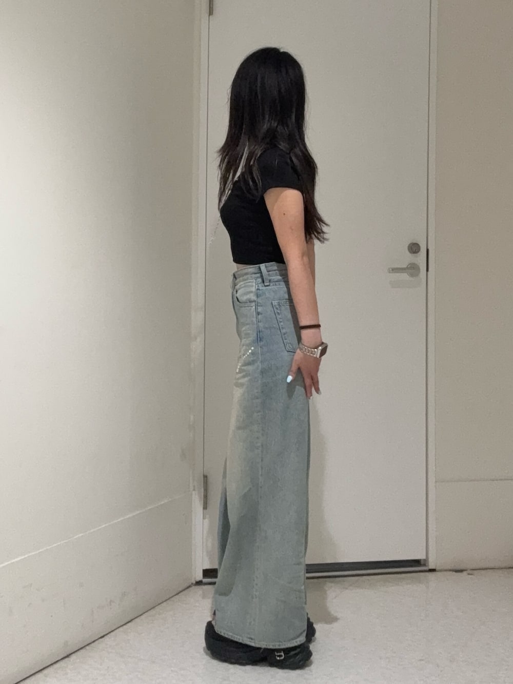 ブラック系のTシャツ/カットソー、ブルー系のデニムパンツ、ブラック系のサンダルを着用したレディースの春コーディネートの2枚目の写真