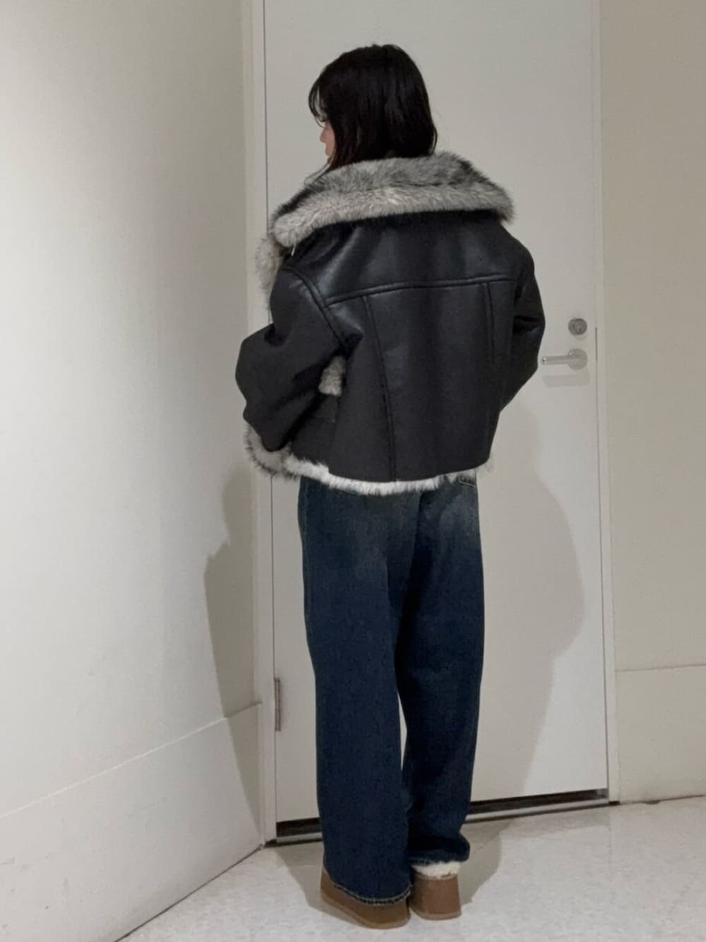 ブラック系のブルゾン、ブルー系のデニムパンツ、ベージュ系のスリッポンを着用したレディースの秋コーディネートの3枚目の写真