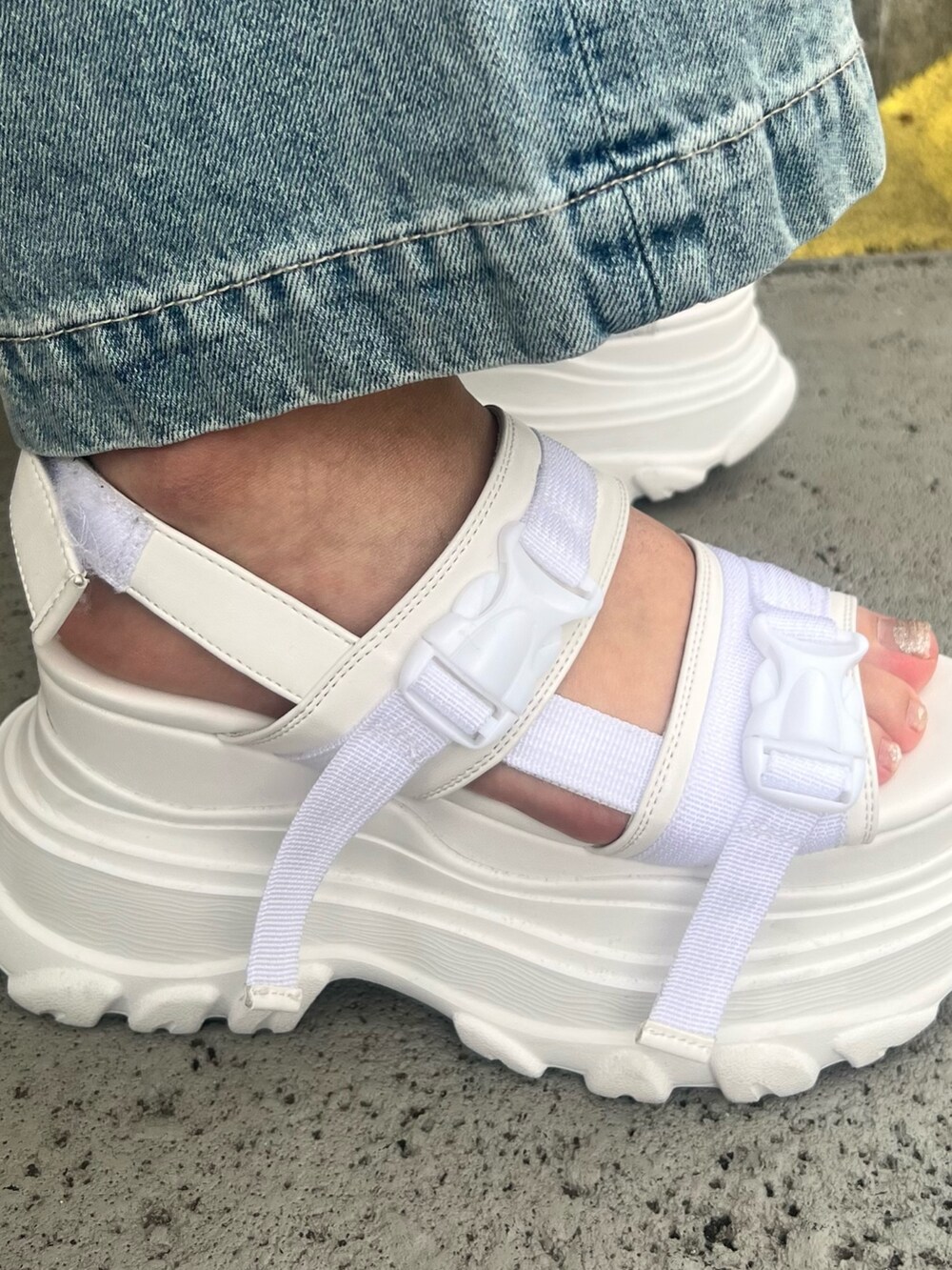 ブルー系のデニムパンツ、パープル系のチューブトップ、ホワイト系のシャツ/ブラウスを着用したレディースの春コーディネートの8枚目の写真