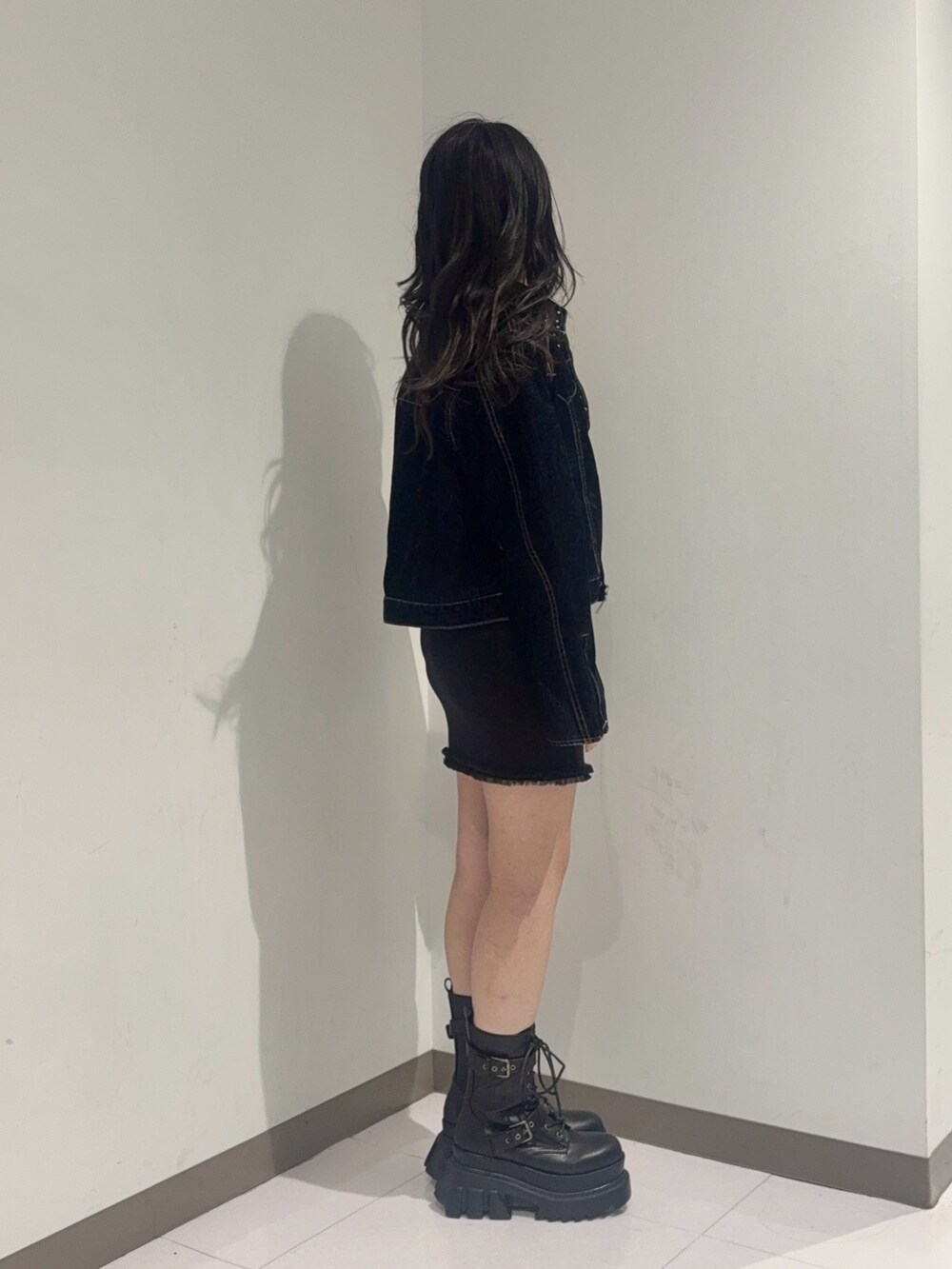 ブルー系のデニムジャケット、ブラック系のブーツ、ブラック系のワンピースを着用したレディースの夏コーディネートの4枚目の写真