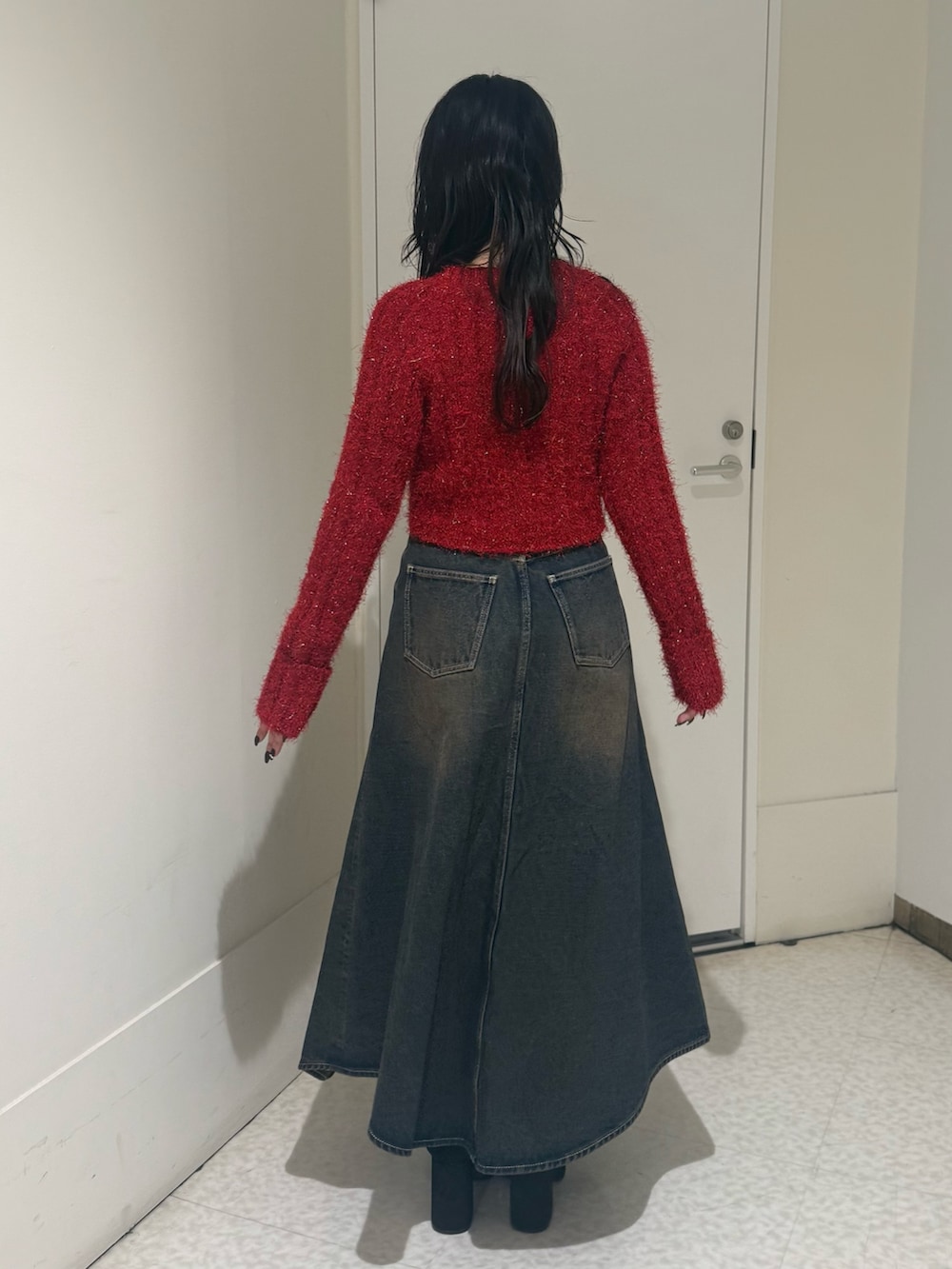 ブラック系のブーツ、ブルー系のデニムスカート、レッド系のカーディガン/ボレロを着用したレディースの秋コーディネートの3枚目の写真