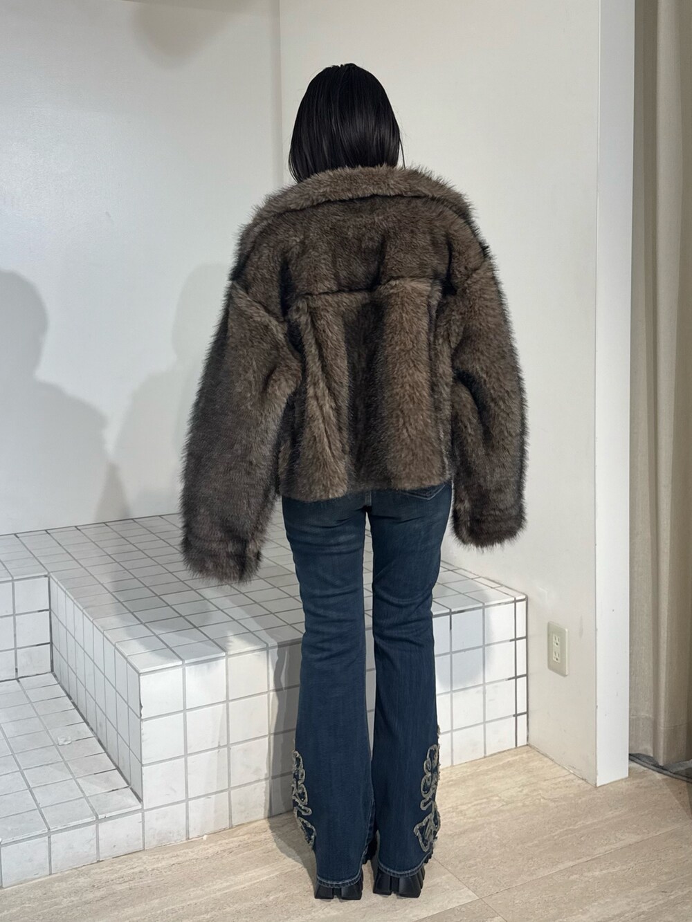ブラウン系のブルゾン、ブルー系のデニムパンツ、ブラック系のブーツを着用したレディースの秋コーディネートの3枚目の写真