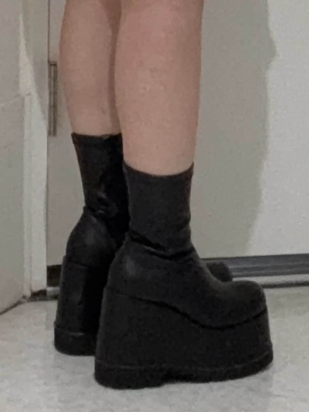 ブラック系のブーツ、ブラック系のパーカー、ブラック系のキャップを着用したレディースの春コーディネートの5枚目の写真