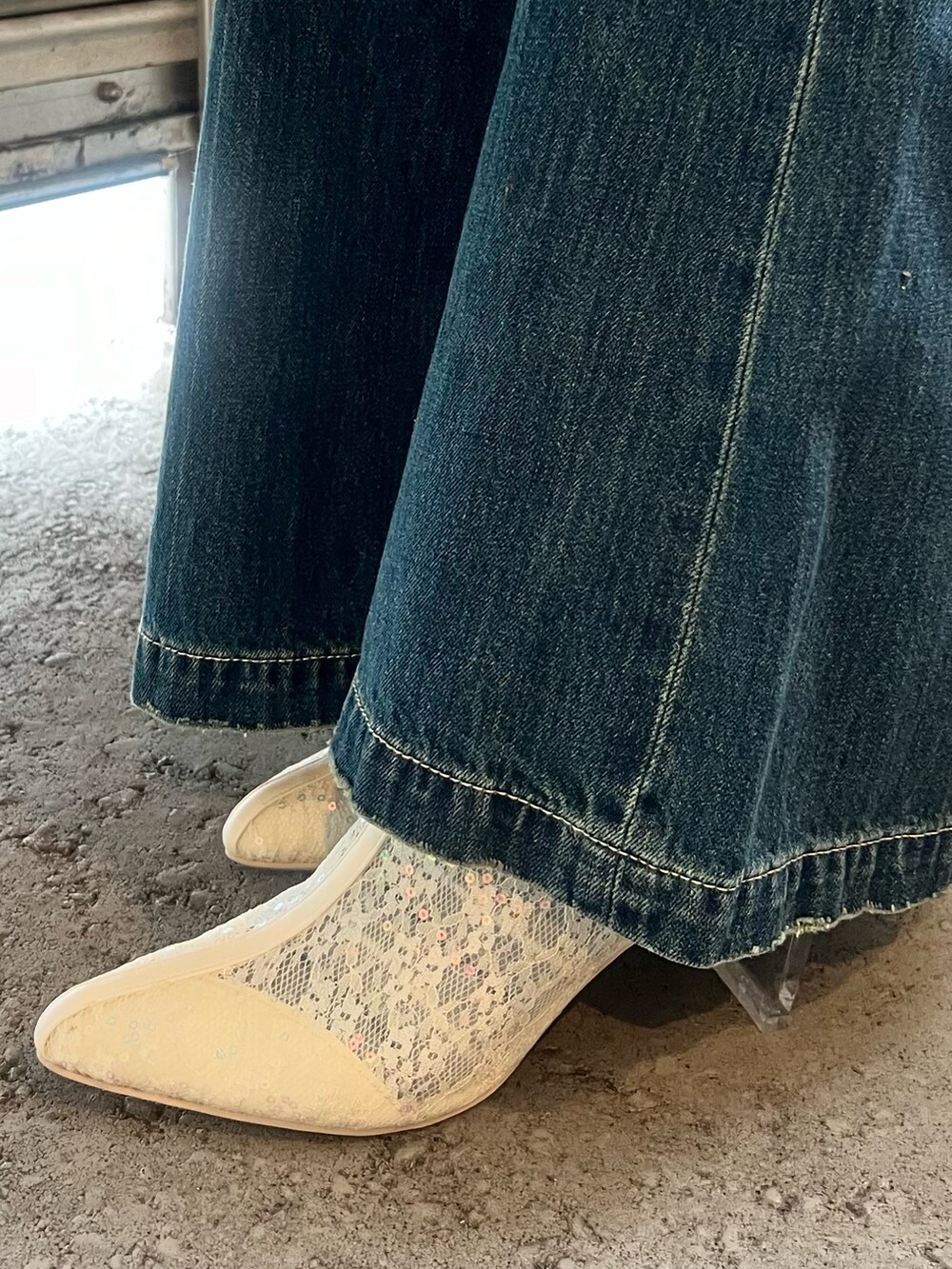 ブルー系のデニムパンツ、ホワイト系のブーツ、ブラック系のニット/セーターを着用したレディースの春コーディネートの8枚目の写真