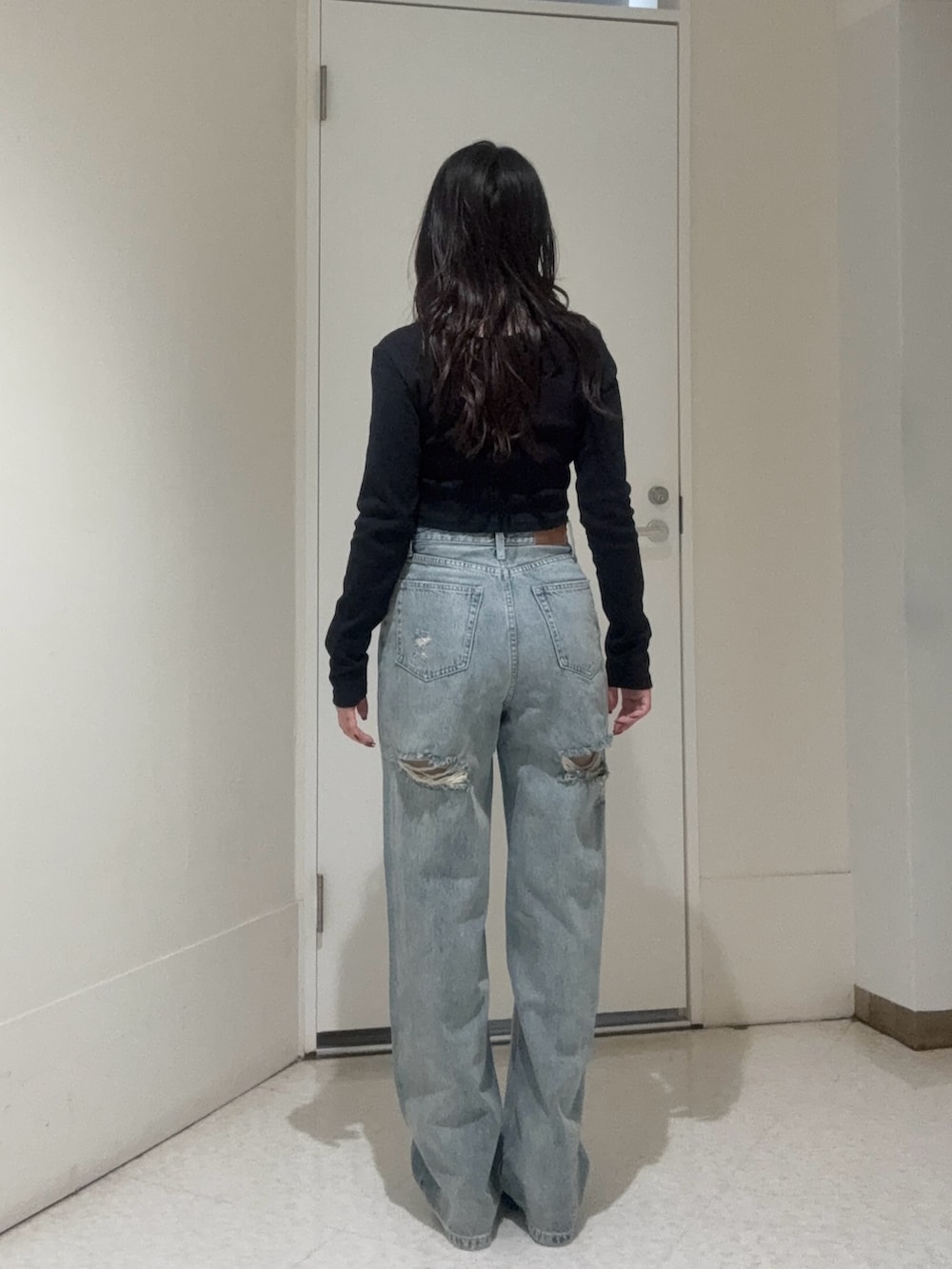 ブラック系のブーツ、ブルー系のデニムパンツ、ブラック系のTシャツ/カットソーを着用したレディースの秋コーディネートの3枚目の写真
