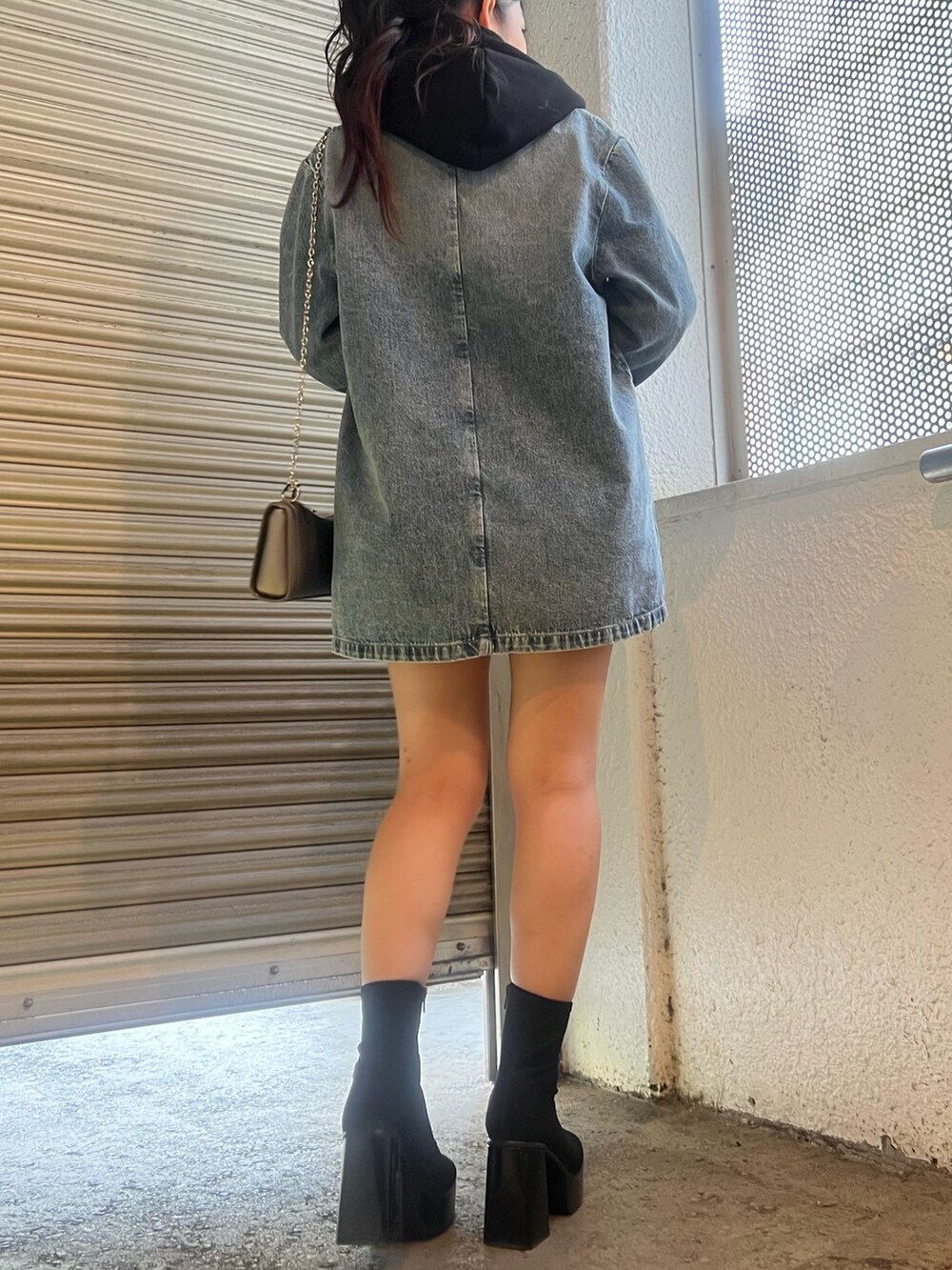 ブルー系のデニムジャケット、ブルー系のデニムパンツ、その他のブーツを着用したレディースの秋コーディネートの3枚目の写真