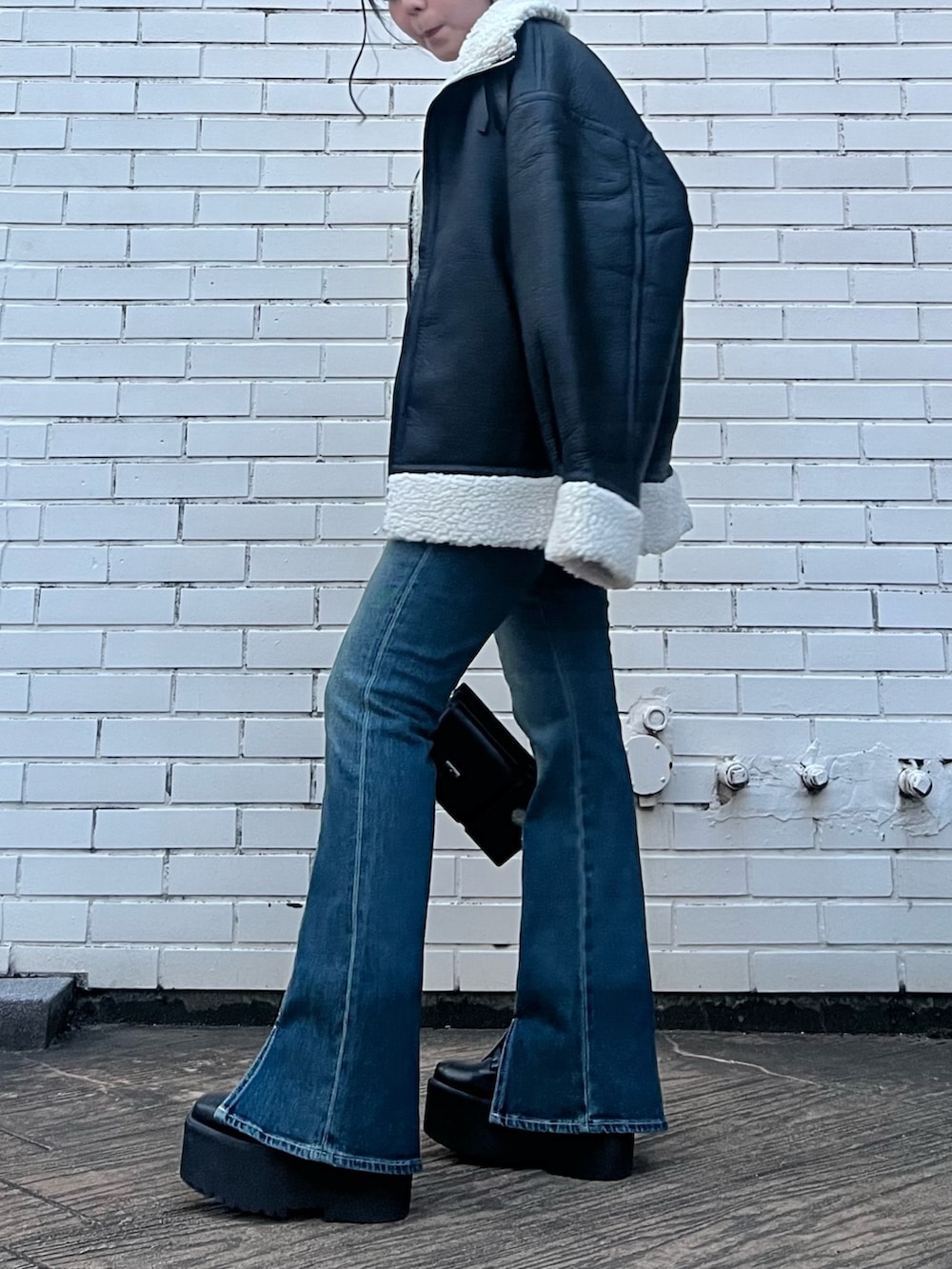 その他のムートンコート、ブルー系のデニムパンツ、ブラック系のショルダーバッグを着用したレディースの夏コーディネートの5枚目の写真