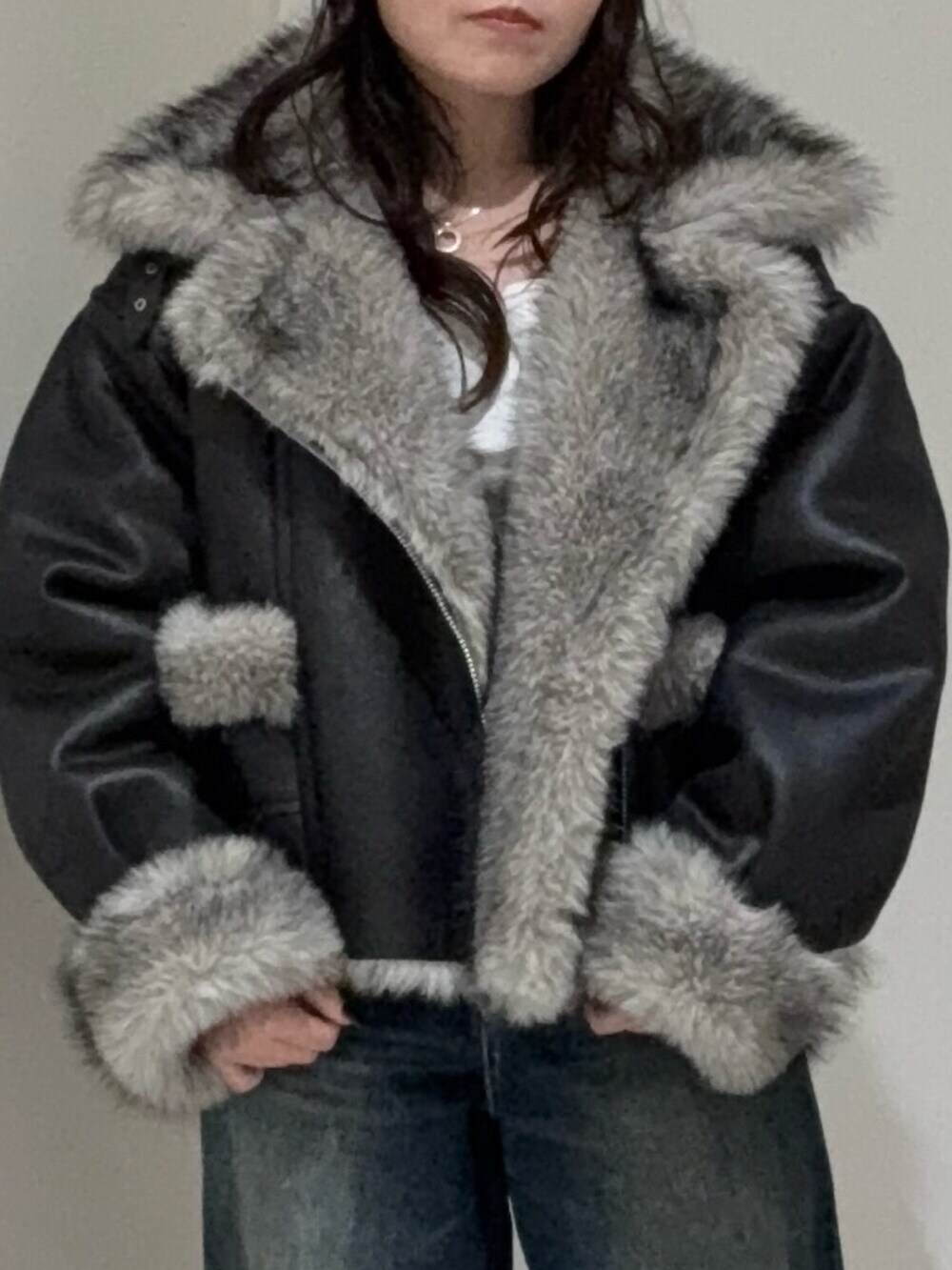 ブラック系のブルゾン、ブルー系のデニムパンツ、ベージュ系のスリッポンを着用したレディースの秋コーディネートの4枚目の写真