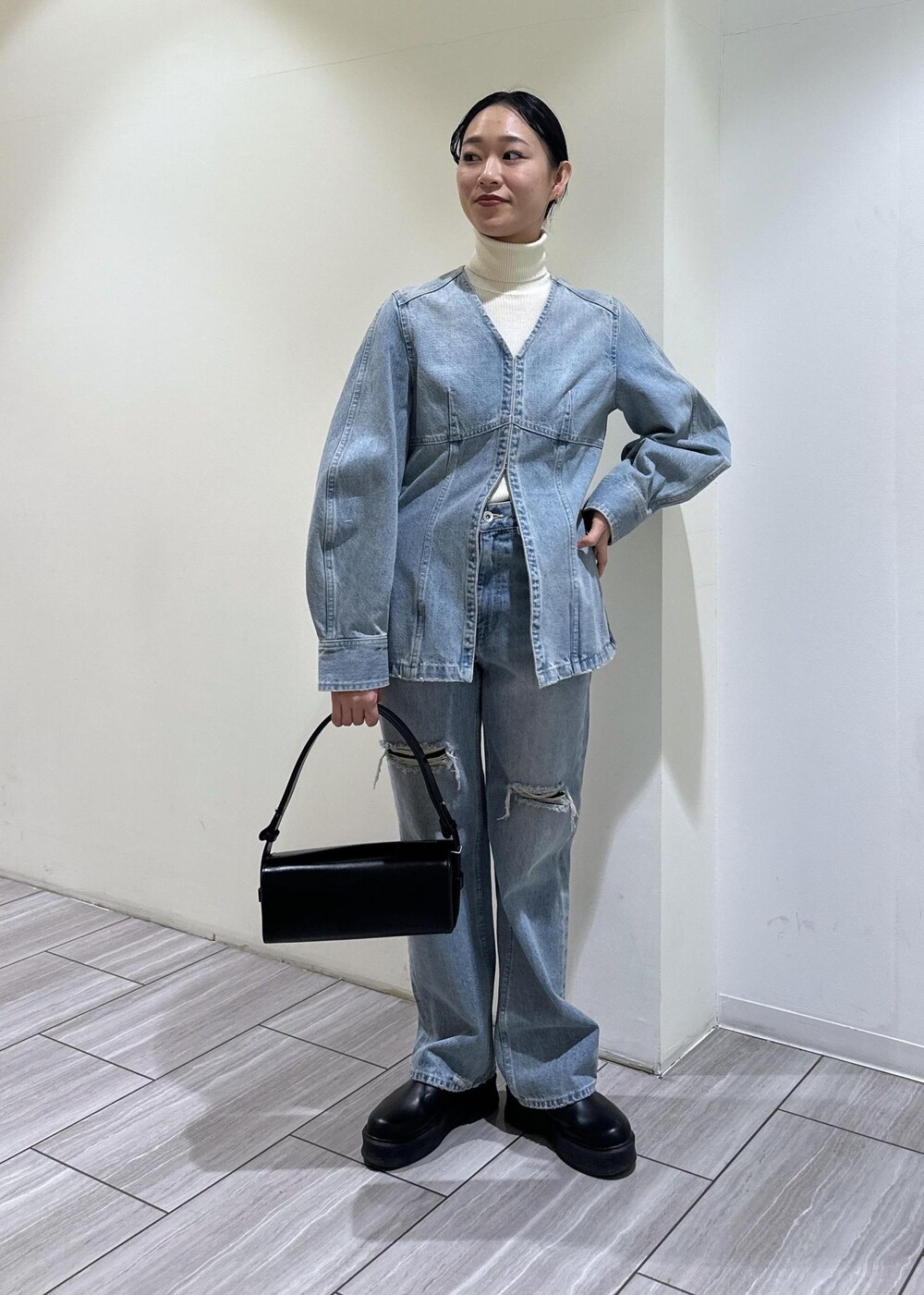 ブラック系のサンダル、ブラック系のハンドバッグ、ブルー系のシャツ/ブラウスを着用したレディースの冬コーディネートの2枚目の写真