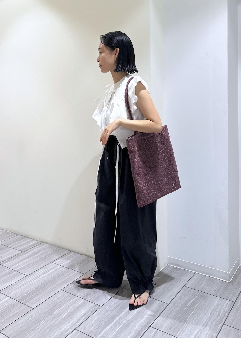 ブラック系のサンダル、ホワイト系のTシャツ/カットソー、ブラック系のその他パンツを着用したレディースの夏コーディネートの3枚目の写真