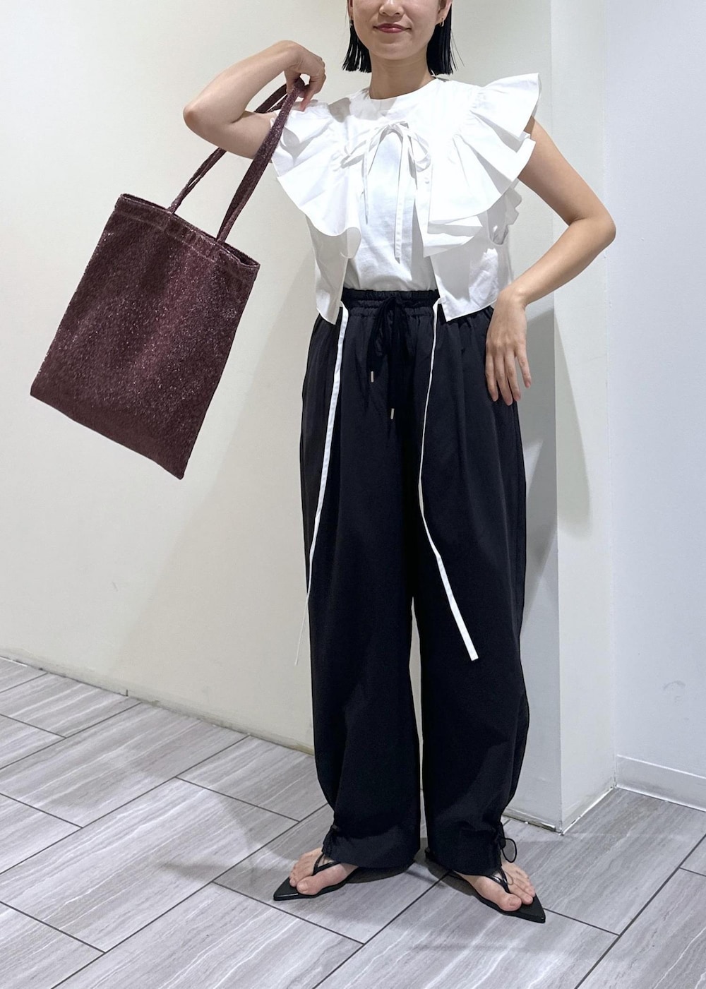 ブラック系のサンダル、ホワイト系のTシャツ/カットソー、ブラック系のその他パンツを着用したレディースの夏コーディネートの7枚目の写真