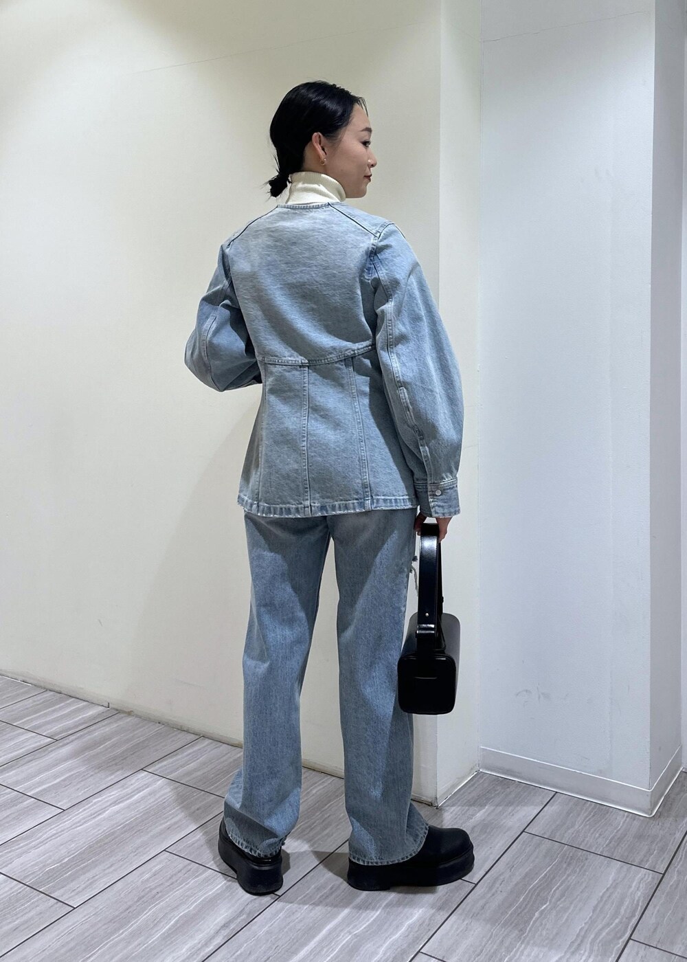 ブラック系のサンダル、ブラック系のハンドバッグ、ブルー系のシャツ/ブラウスを着用したレディースの冬コーディネートの4枚目の写真