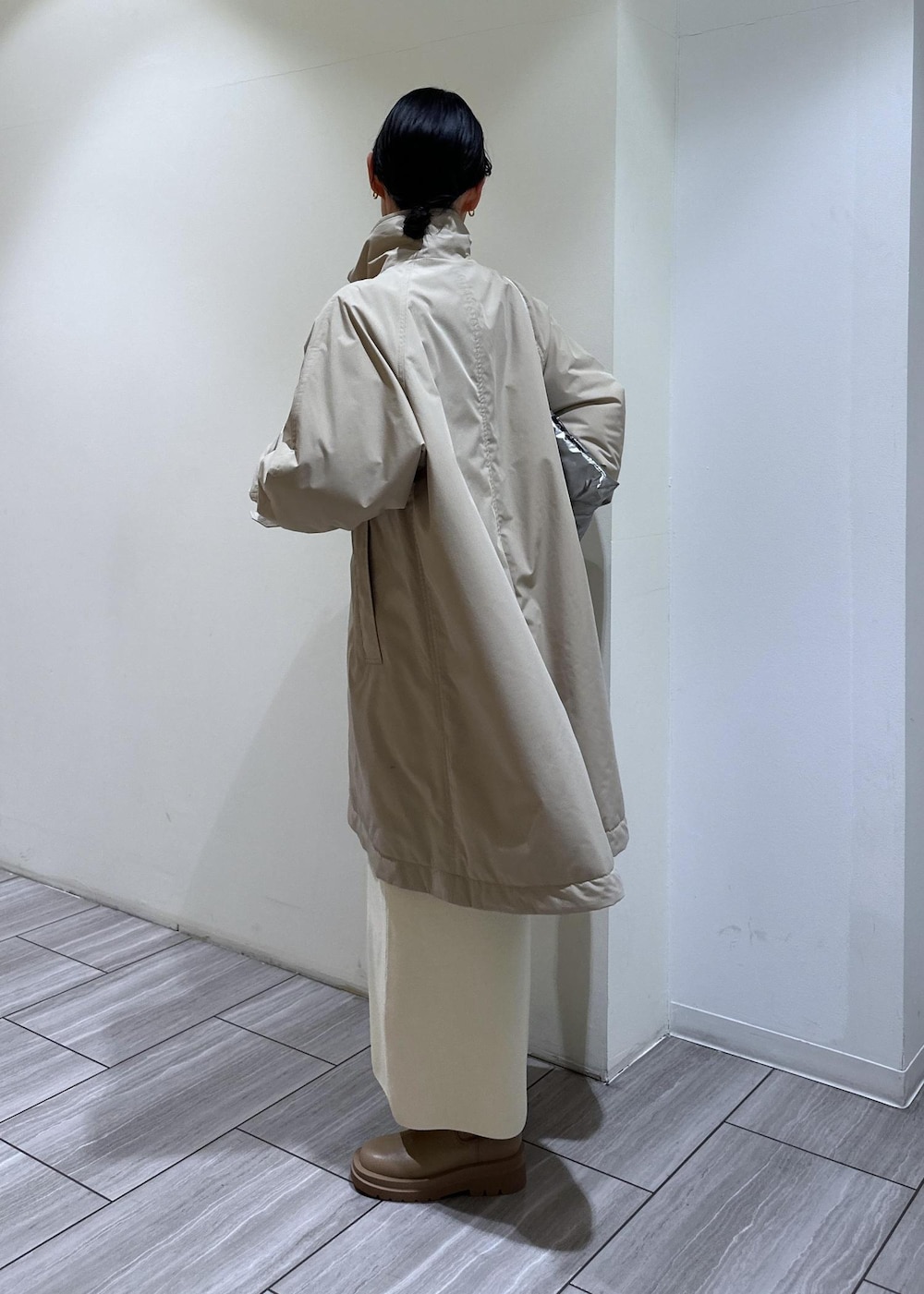 ベージュ系のブーツ、ホワイト系のワンピース、ベージュ系のその他アウターを着用したレディースの冬コーディネートの4枚目の写真