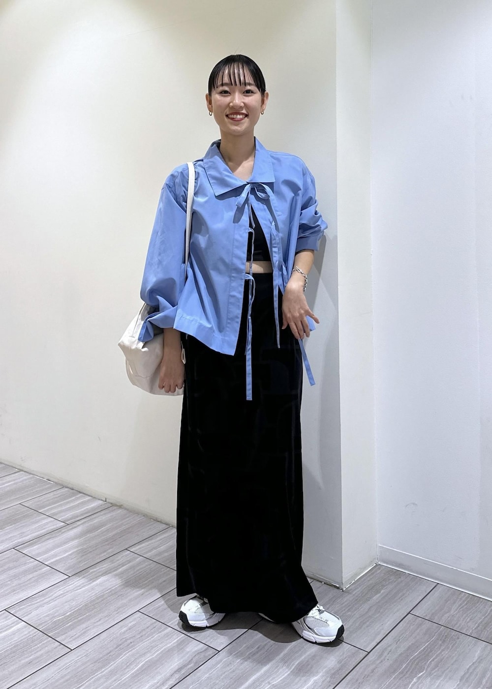 ブラック系のスカート、ブルー系のシャツ/ブラウス、ホワイト系のボディバッグ/ウエストポーチを着用したレディースの秋コーディネートの2枚目の写真