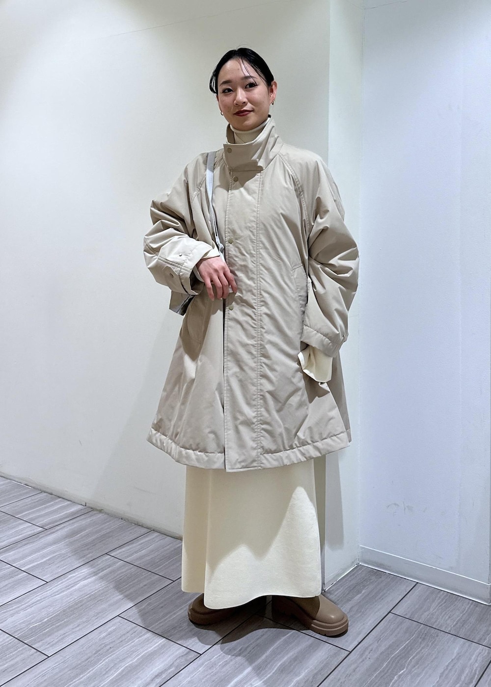 ベージュ系のブーツ、ホワイト系のワンピース、ベージュ系のその他アウターを着用したレディースの冬コーディネートの8枚目の写真