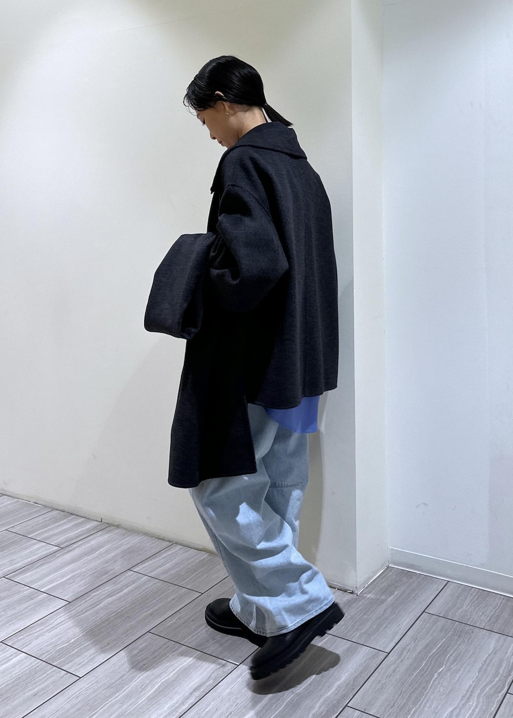 ブルー系のデニムパンツ、ベージュ系のトートバッグ、ブラック系のブーツを着用したレディースの秋コーディネートの3枚目の写真