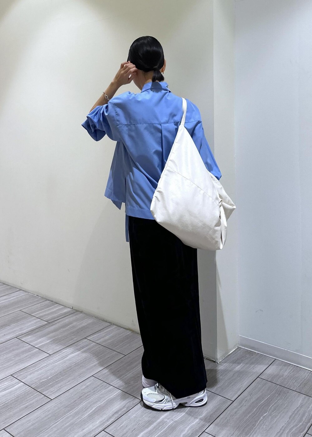 ブラック系のスカート、ブルー系のシャツ/ブラウス、ホワイト系のボディバッグ/ウエストポーチを着用したレディースの秋コーディネートの4枚目の写真