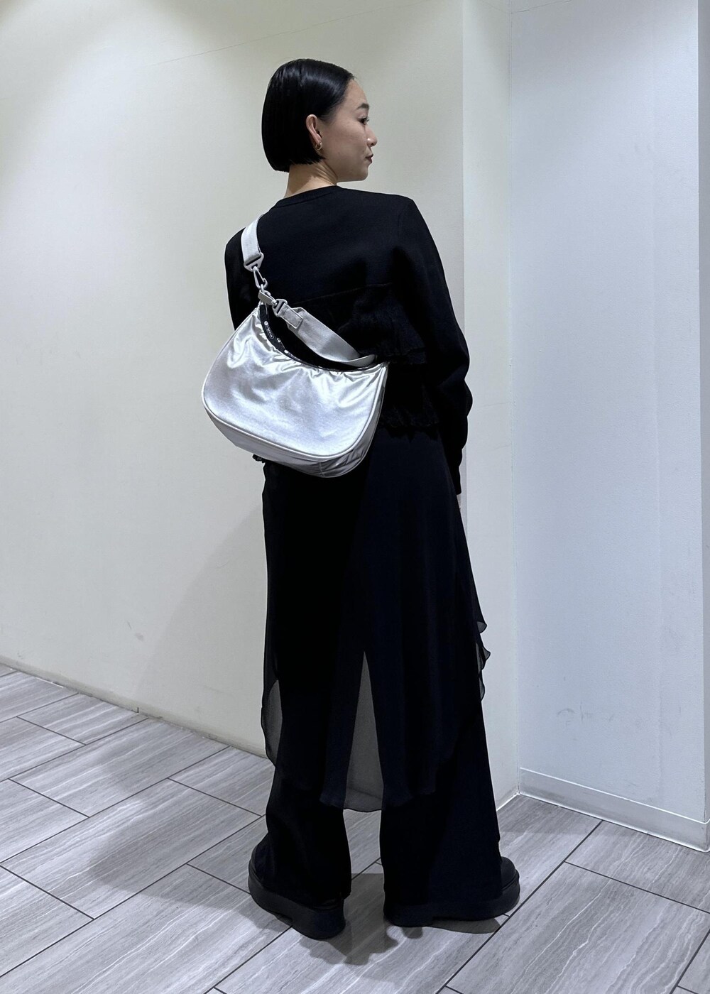 ブラック系のサンダル、ブラック系のカーディガン/ボレロ、シルバー系のショルダーバッグを着用したレディースの冬コーディネートの3枚目の写真