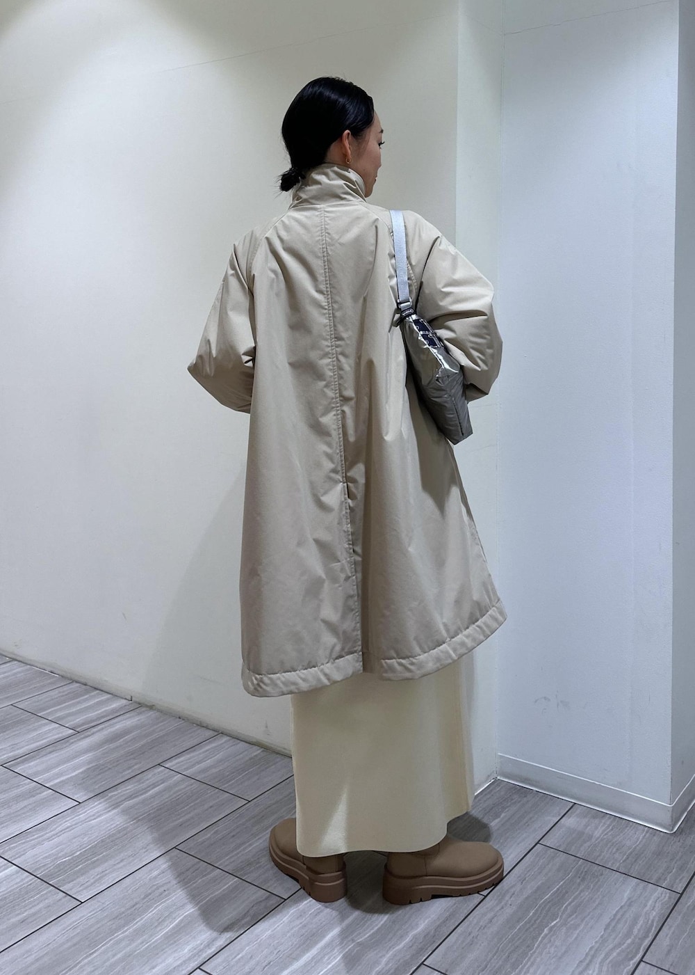 ベージュ系のブーツ、ホワイト系のワンピース、ベージュ系のその他アウターを着用したレディースの冬コーディネートの5枚目の写真