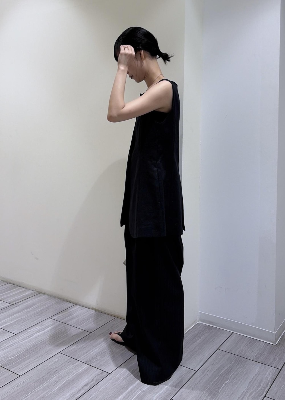 ベージュ系のクラッチバッグ、ブラック系のサンダル、ブラック系のその他パンツを着用したレディースの夏コーディネートの3枚目の写真