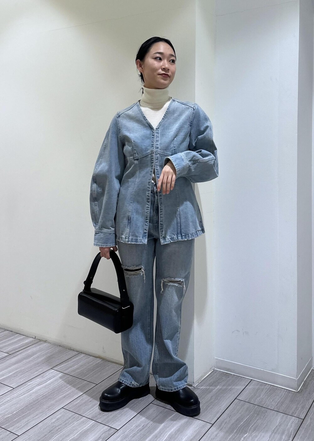 ブラック系のサンダル、ブラック系のハンドバッグ、ブルー系のシャツ/ブラウスを着用したレディースの冬コーディネートの7枚目の写真